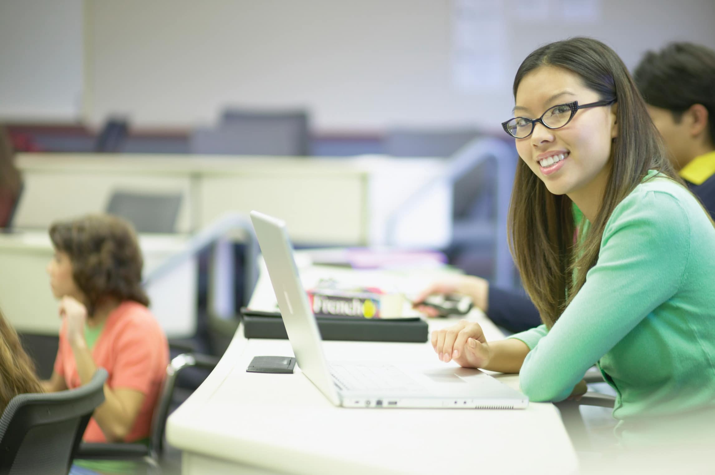 Side profile of a young woman in front of a laptop